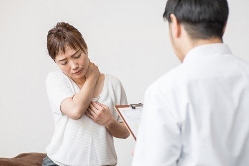 首を押さえている女性