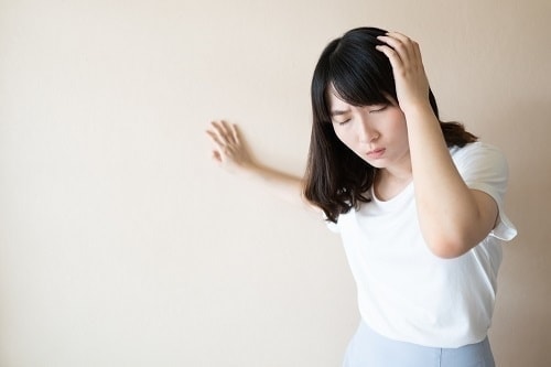 頭を押さえている女性画像